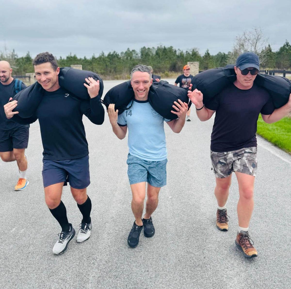 Team members running together with training weights, showcasing teamwork and dedication.